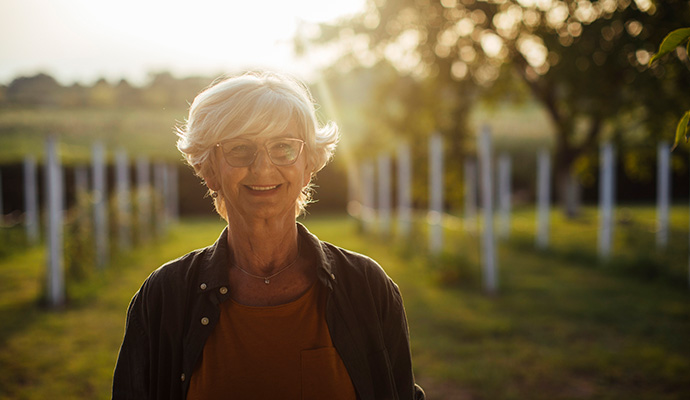 woman standing in green field with sunlight